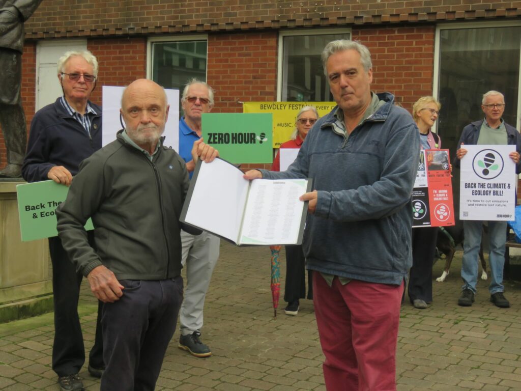 Image with local campainger, Philip Oliver, handing in petition signatures to MP, Mark Garnier.